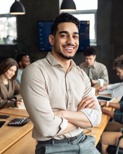 Young bearded businessman sitting on desk and posing